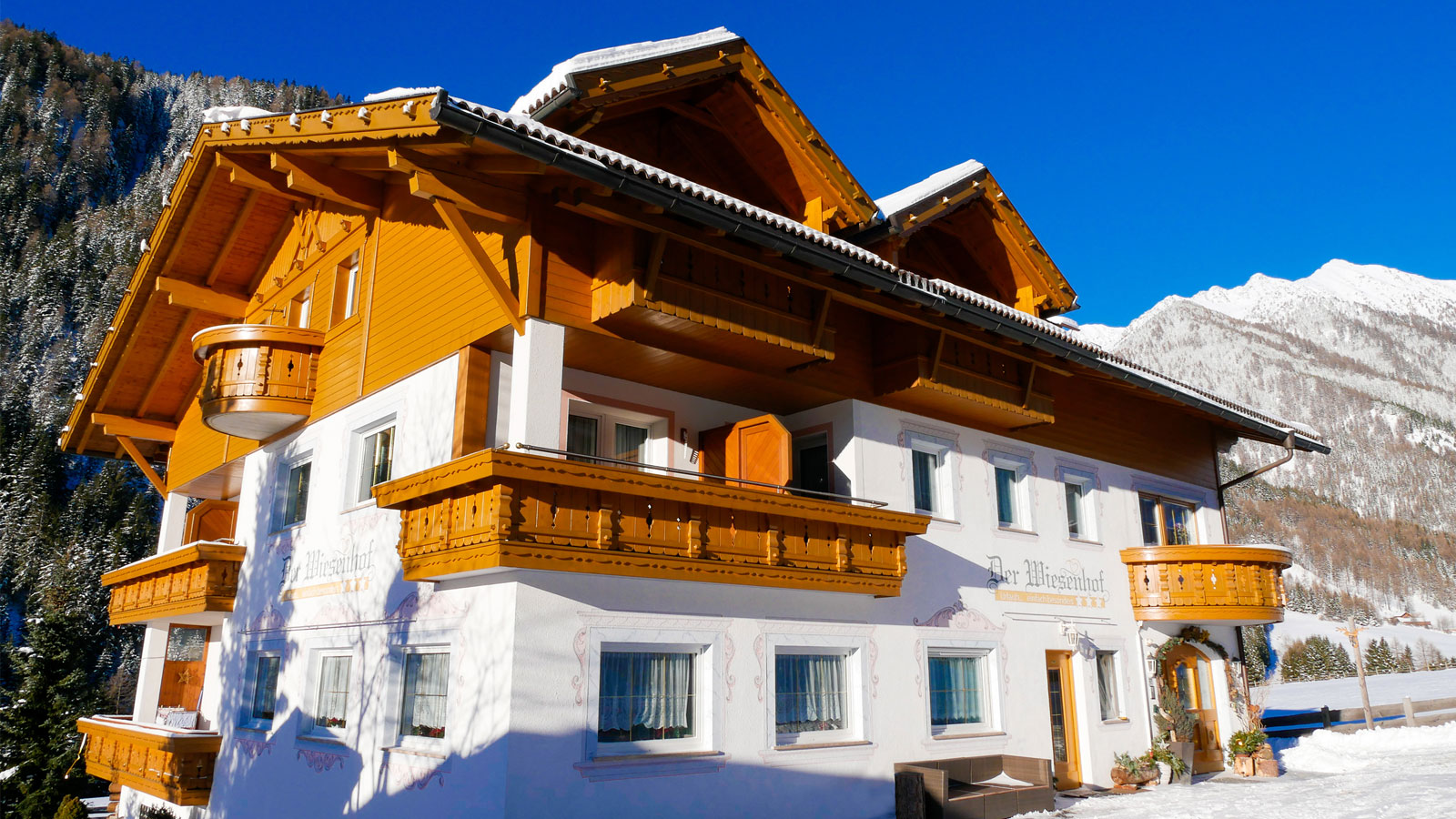 Das Hotel Der Wiesenhof in der Wintersaison umgeben von verschneiten Bergen