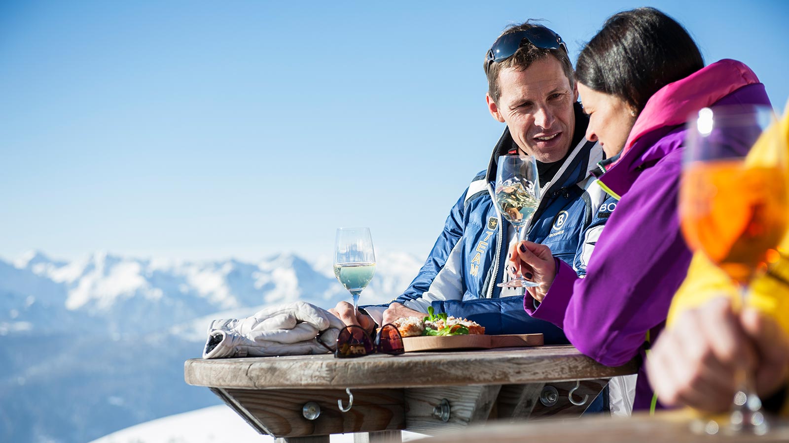 Ein Paar genießt einen Snack in der Sonne nach einem Tag auf den Skiern
