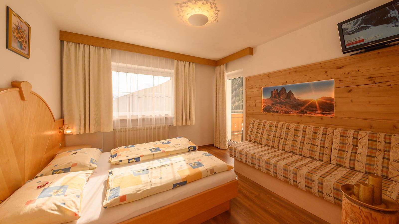 Blick auf einen Teil des Zimmers mit Balkon und Couch im Hotel