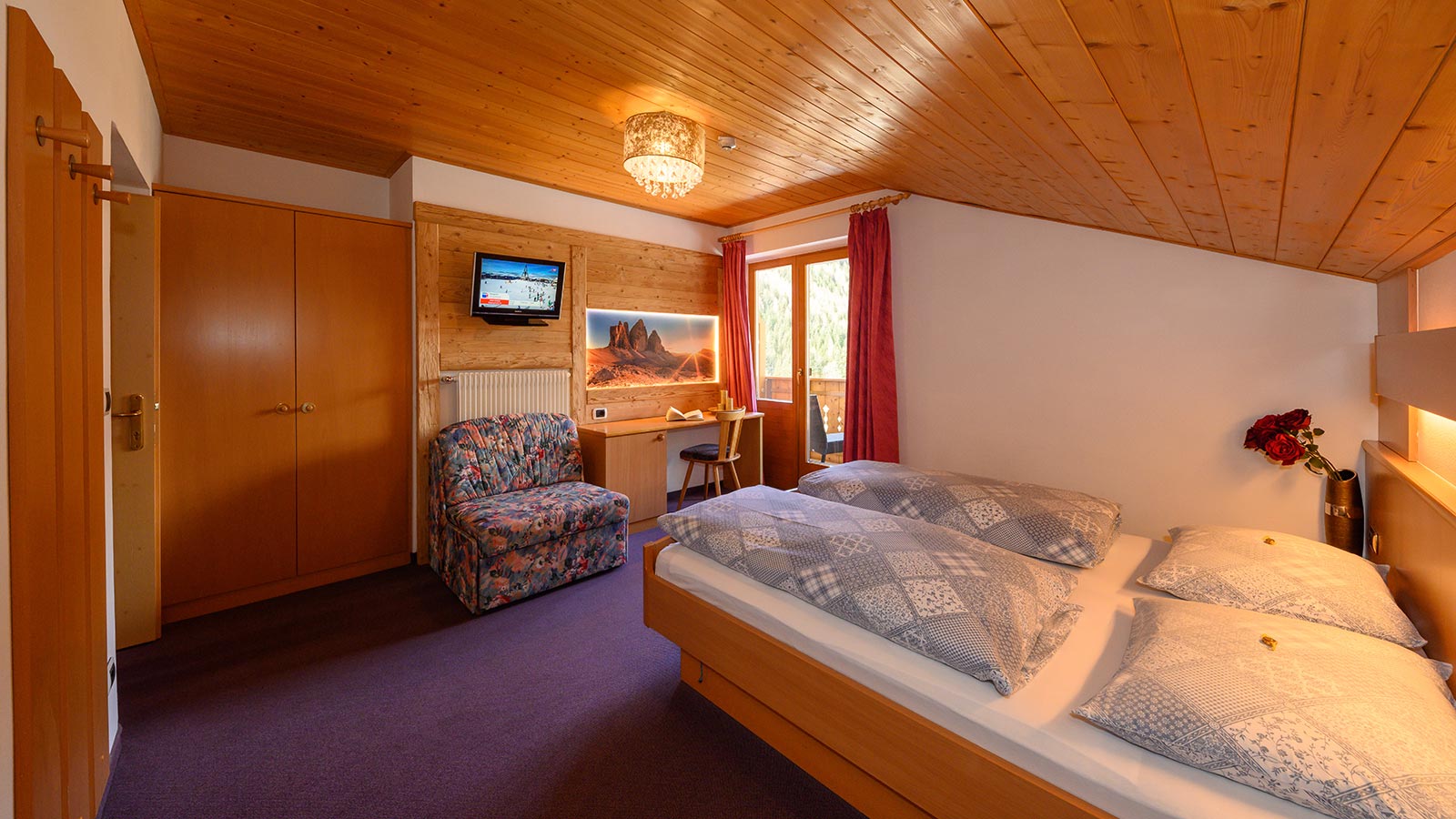 Blick auf ein Bett in einem der Zimmer des Hotels Der Wiesenhof in Vals